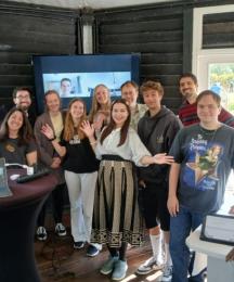 A group of people standing together in a room and smiling