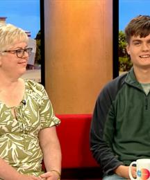 A mother and son sitting on a sofa