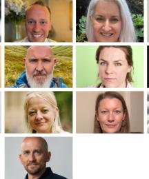 Heads and shoulders of thirteen people, six men and seven women