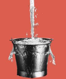 A bucket, with water pouring into it and spilling over the sides