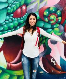 A woman standing in front of a dragon mural