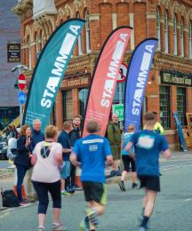 People on a sponsored run, with spectators cheering them on