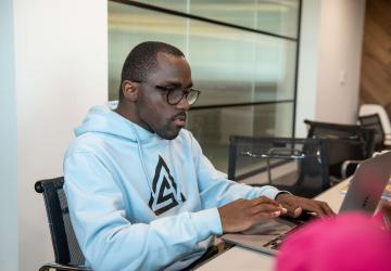 A man sitting at a desk working on a laptop