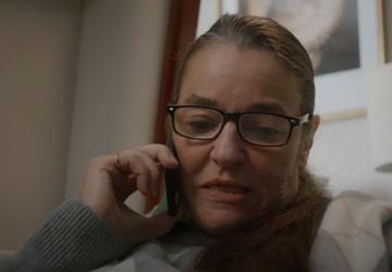A woman speaking into a telephone