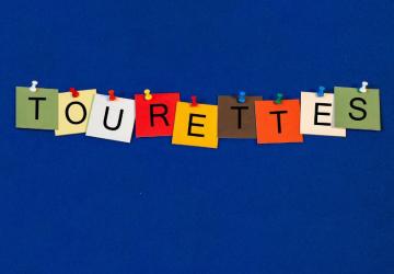 An illustrated washing line, with cards pegged to it, each with a letter, spelling out the word 'Tourette's'