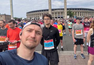 A man taking a selfie photo surrounded by fun runners
