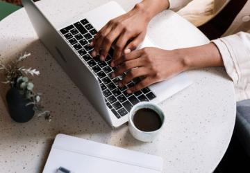 A pair of hands typing on a laptop computer