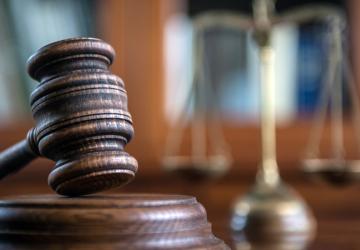 A gavel and block, in a courtroom setting