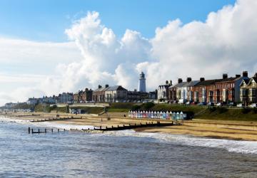A coastal town, with a row of houses and a lighthouse between them