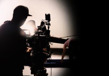 A camera operator filming a set