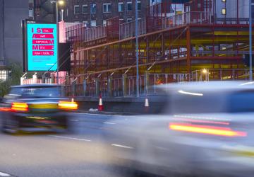 A busy road with an outdoor advertisement displaying the I Stammer campaign