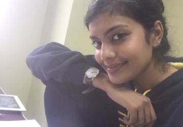 A young woman at a desk smiling for the camera