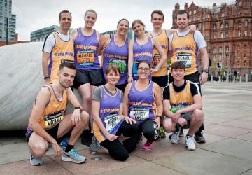 A group of people in running costumes posing for the camera