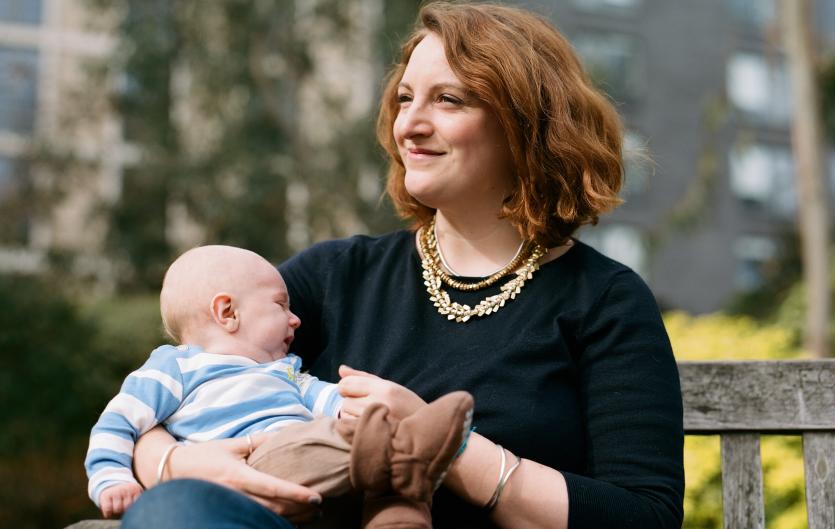 What is Stammering? A woman holding a baby on a park bench.