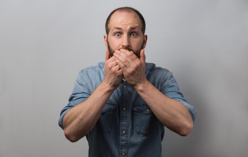 An unusual heckler Aidan Green covering his mouth with his hands in staged surprise