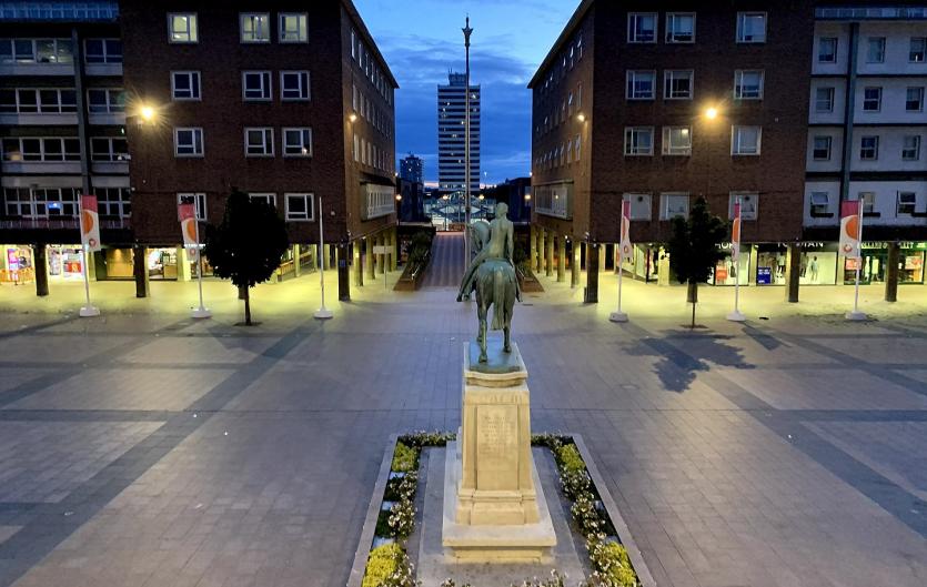 Coventry Stammerers A square in a city centre in the evening, with a statue in the centre