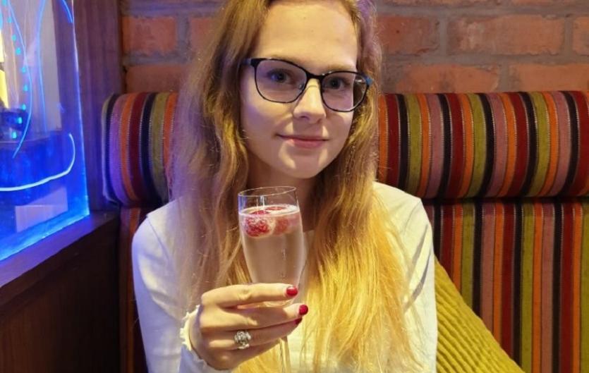 Dating with a stammer A woman smiling at the camera and raising a glass
