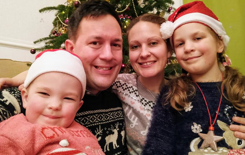 The author, his partner and two daughters in Christmas jumpers, by a Christmas tree