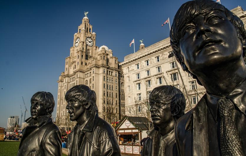 Statues of the Beatles with a backdrop of the Liver Building in Liverpool