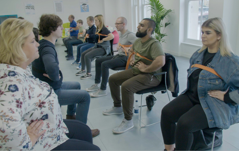 People practicing costal breathing in a group therapy setting