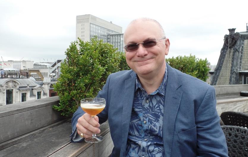 A man looking at the camera with a glass in his hand