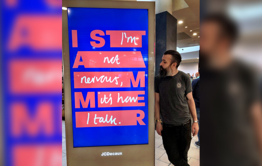 I Stammer Campaign Scroobius Pip beside an outdoor campaign advert