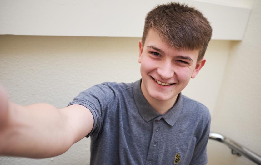A teenager looking at the camera and smiling