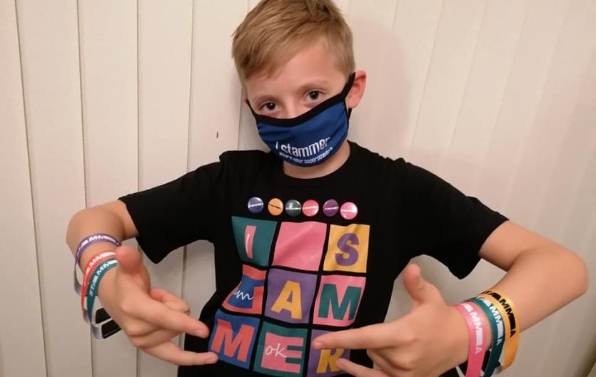 A young boy wearing our t-shirt, wristbands, face mask and badges