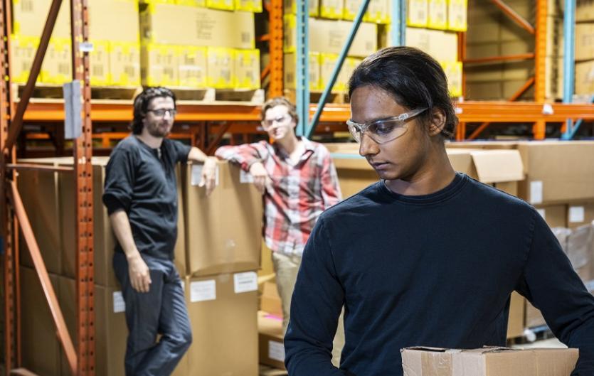 Bullying at Work A warehouse employee being watched and possibly laughed at by colleagues