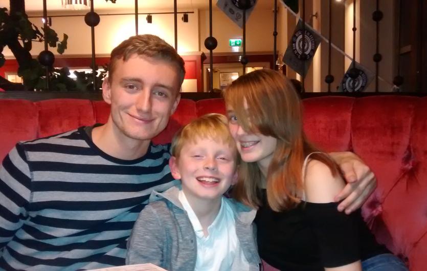 My family: our story The author's three children (two of them adults) sitting together, smiling