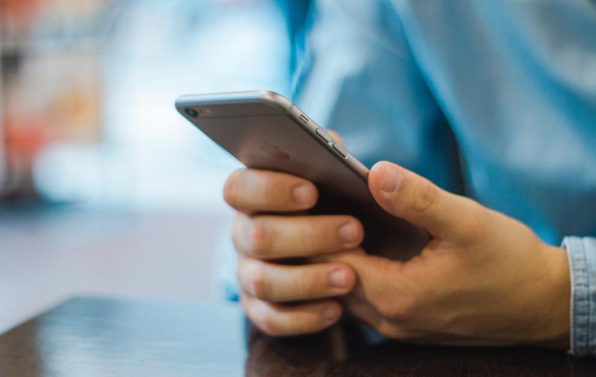Text Relay service if phone calls are difficult A man's hands holding a smartphone