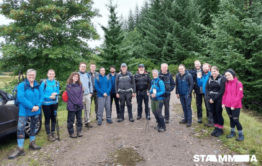 Walk & Talk 2021 A group shot of people dressed in walking gear, with a woodland backdrop