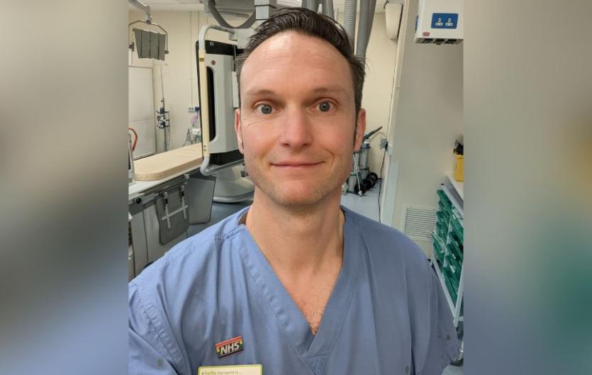 Stammering helps me empathise with patients A man in a medical uniform looking at the camera and smiling