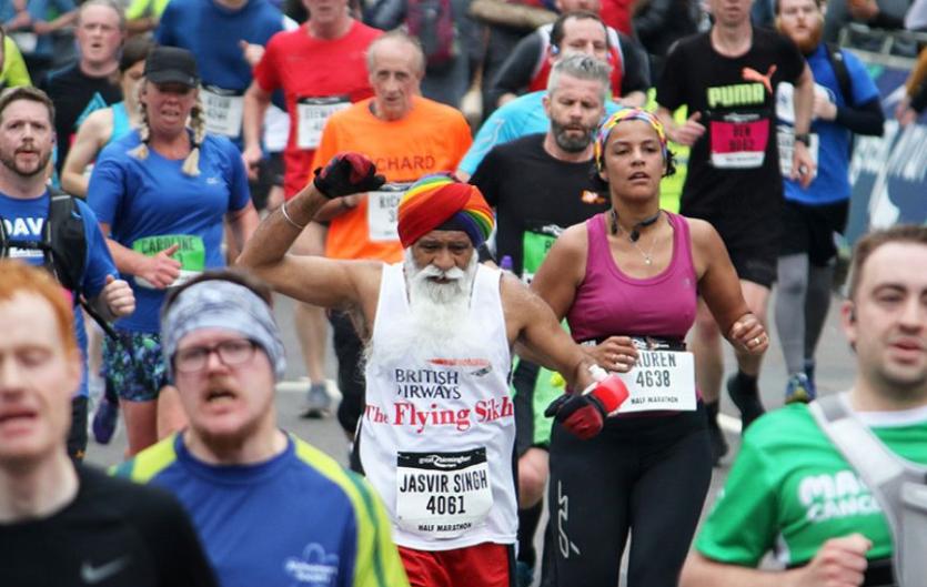An elderly man doing a sponsored run surrounding by other runners