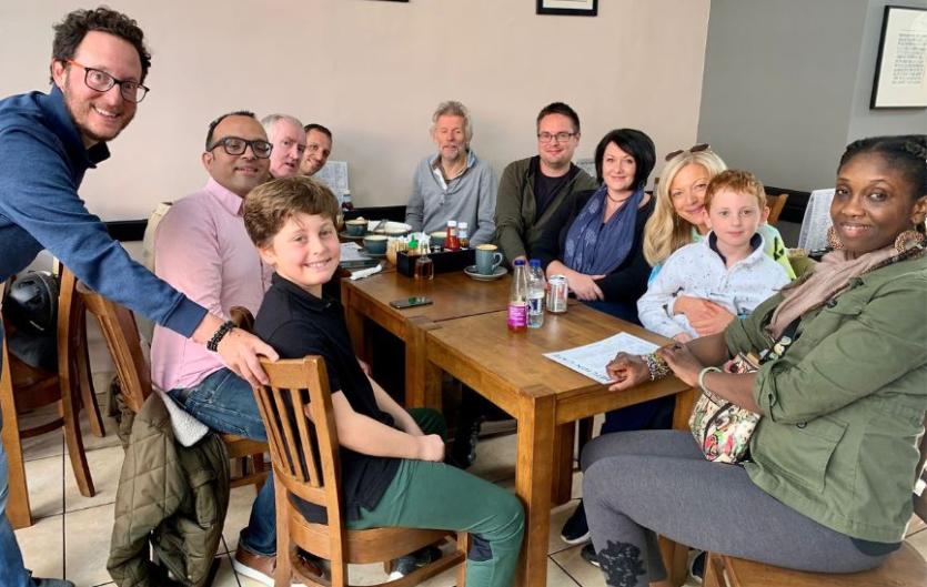 Support groups A diverse group of people around a table looking at the camera and smiling