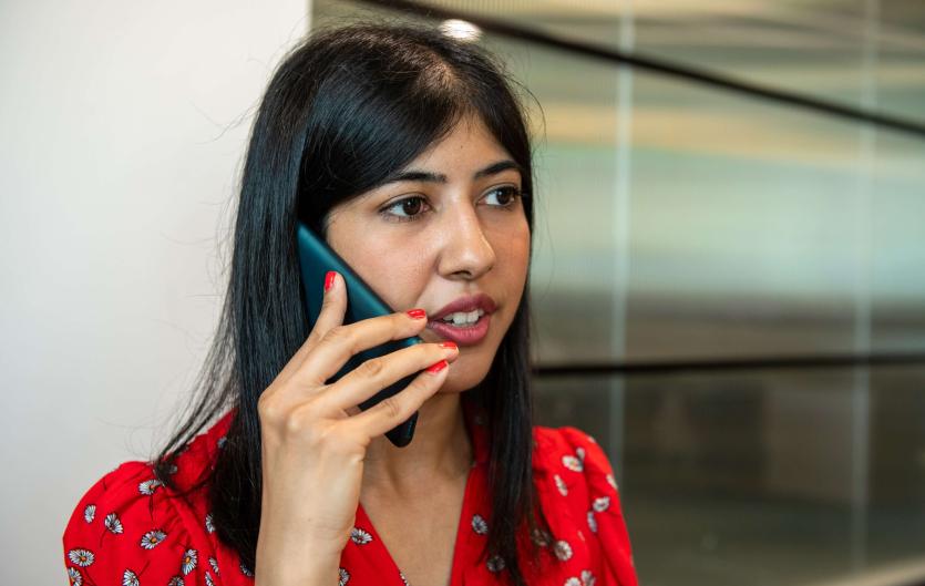 Making GP Bookings Accessible A woman speaking into a mobile phone and looking anxious