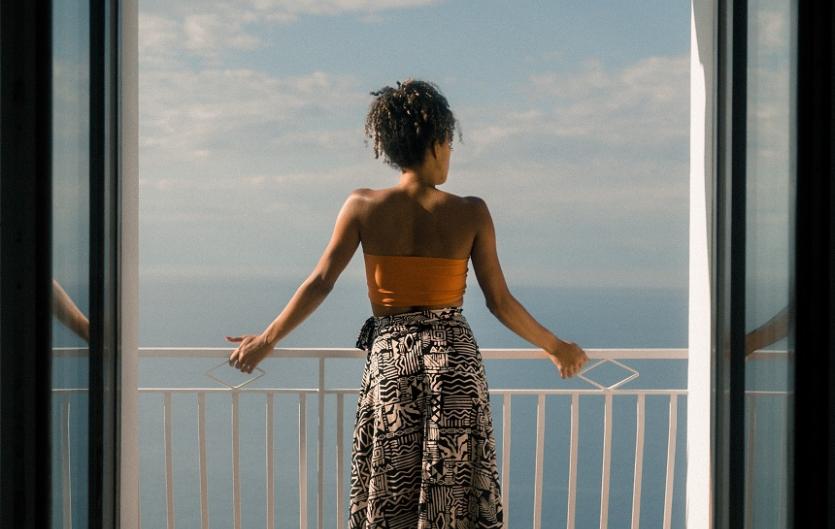 A woman on a balcony looking out to sea