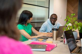 A man talking to a woman at a desk in an office