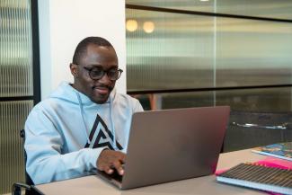 A man sitting at a desk working on a laptop