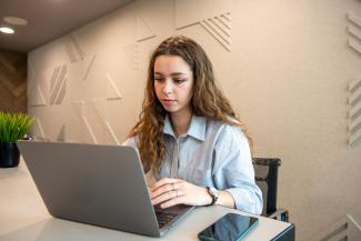 A woman sitting at a desk using a laptop