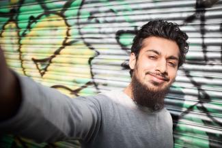 A young man taking a selfie and smiling
