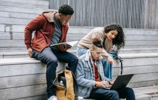 Three college students sitting and studying together