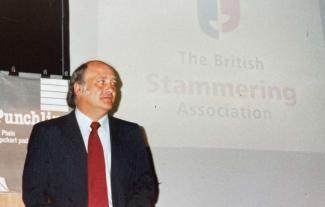 A man standing in front of a projector screen