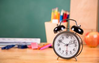 A clock on a classroom desk