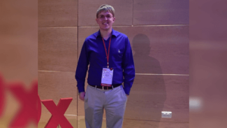 A man wearing a lanyard, smiling