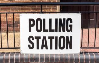 A sign saying 'Polling station' attached to railings