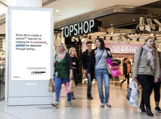 A digital advertisement board in a busy shopping centre