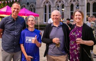 Four people standing and smiling