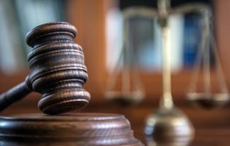 A gavel and block, in a courtroom setting