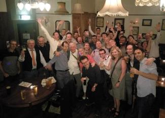 A group of people in a pub looking merry